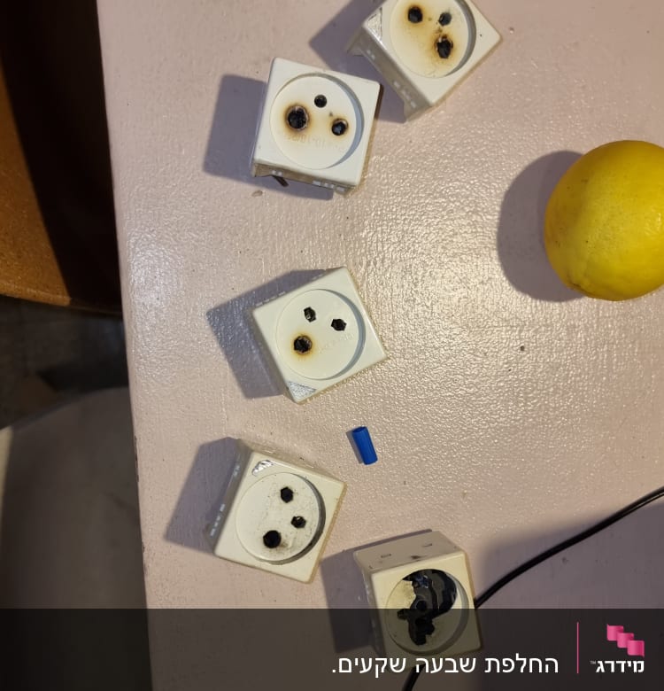 שקעים חשמליים שרופים על שולחן עבודה